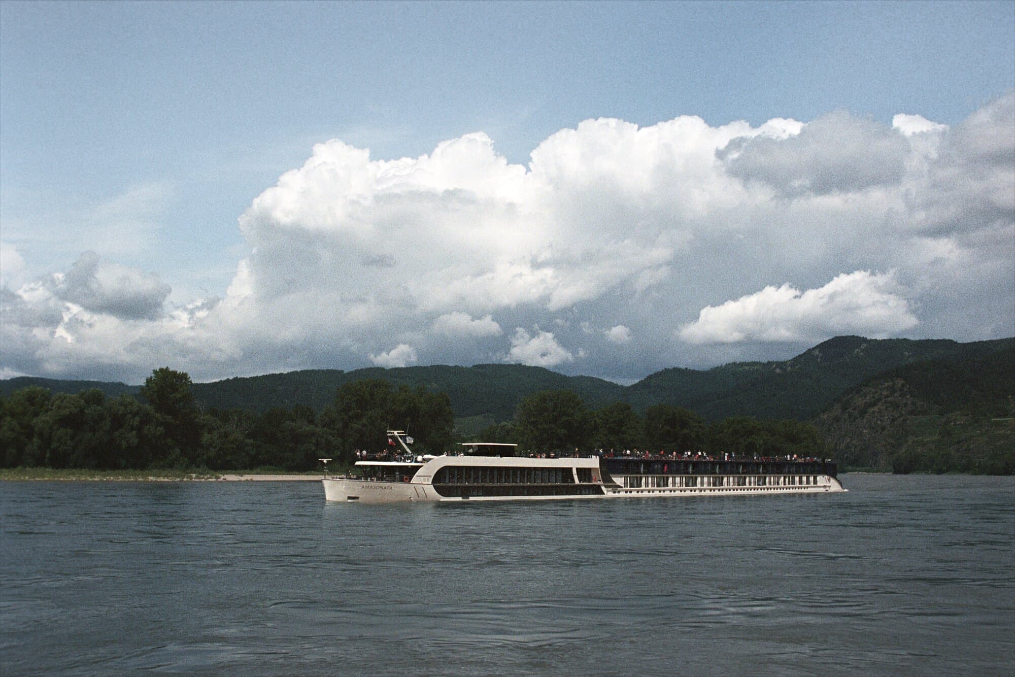 AmaSonata on the river with clouds in the background